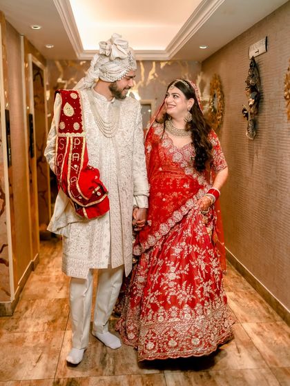 A classic portrait of Payal and Soumil walking down a corridor, their smiles and hand-holding capturing the beginning of their journey as a married couple.