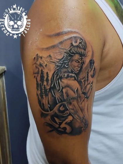 A detailed portrait of Lord Shiva on the upper arm, set against a backdrop of the Himalayas. This piece captures his meditative and powerful presence.