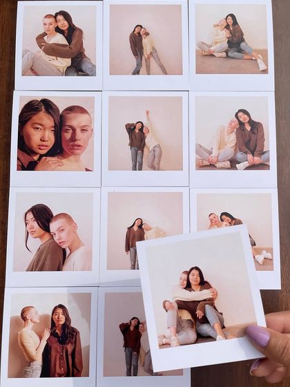 A full set of 12 polaroids from a friendship photoshoot, laid out to show the complete collection. A hand holds one up to show the size and quality.