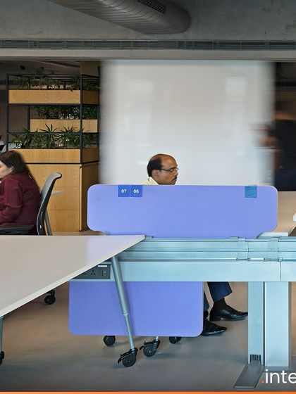 Detail of the mobile desk dividers at Grant Thornton. These elements provide privacy and acoustic separation while being easily movable, giving employees control over their immediate environment and fostering productivity.