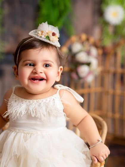 The happiest smile for a first birthday girl. This close-up shot captures the pure joy and excitement of turning one in our beautiful, nature-inspired studio setup.