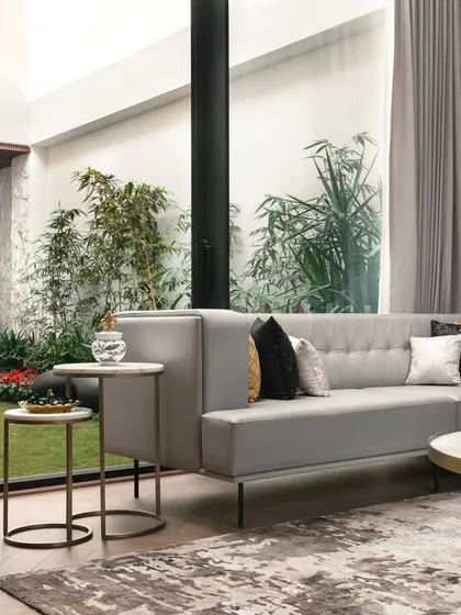 Another view of the living room at the APP Residence, where the comfortable sofa arrangement is oriented towards the lush central courtyard, making nature the focal point.