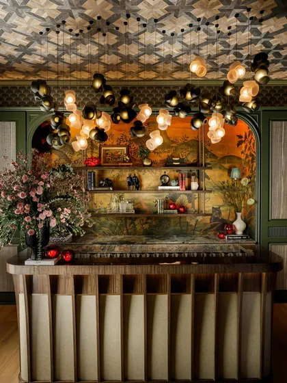 In commercial spaces, lighting sets the entire mood. Here, a custom installation of the Bocci 100 series cascades over a bar, its clustered forms and warm glow creating an inviting and opulent atmosphere for guests. This is an example of a bespoke lighting solution for a high-end hospitality environment.