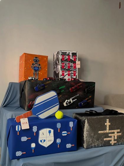 A full view of the themed birthday gifts I curated for Akash Ambani. The collection includes a pickleball-themed box, an Arsenal football tribute, a robot-inspired design, and a box decorated with miniature cars.