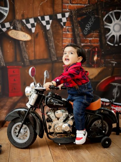 This little biker is ready for an adventure. The action shot captures his excitement as he "rides" the toy motorcycle.