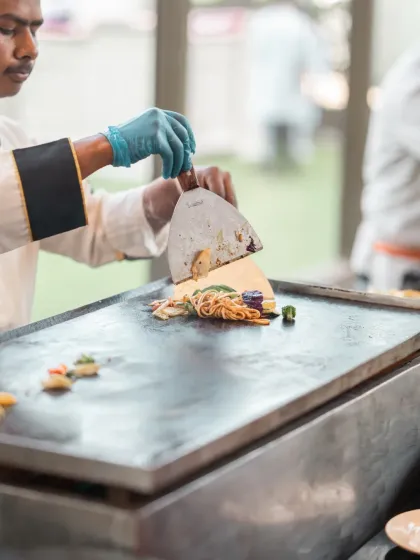 Another shot of the live cooking station, showing the chef skillfully preparing a meal for the guests.