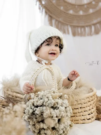 Simple, pure, and full of light. This sitter session highlights the baby's sweet curiosity with a clean, natural, and earthy bohemian setup.