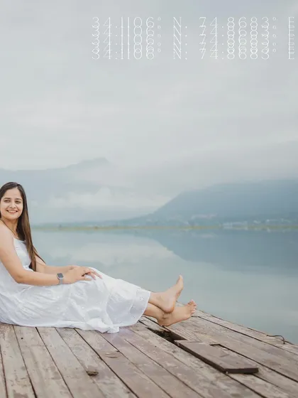 The bride-to-be relaxes on a wooden pier by the lake, a beautiful solo shot from a pre-wedding session.