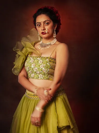 A full-standing portrait of Shruti Marathe in the green lehenga, showing the detailed embroidery on the blouse and the modern silhouette.