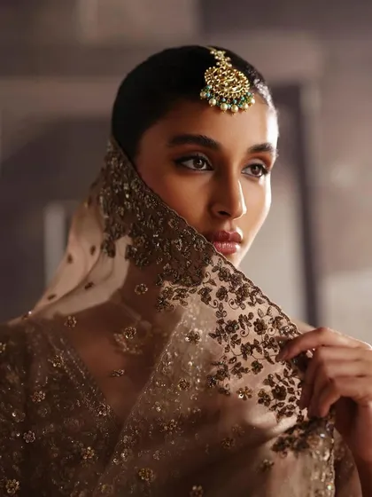 A stunning close-up from the AR by Rhea Kapoor campaign. The model's look is completed with a sheer, embroidered dupatta and a statement maang tikka.