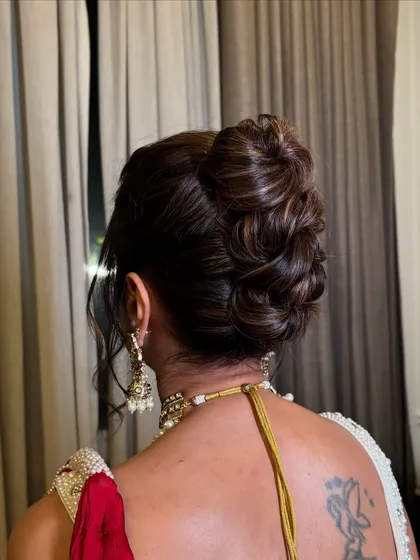 A close-up of the textured high bun, showing the intricate weaving of the hair.