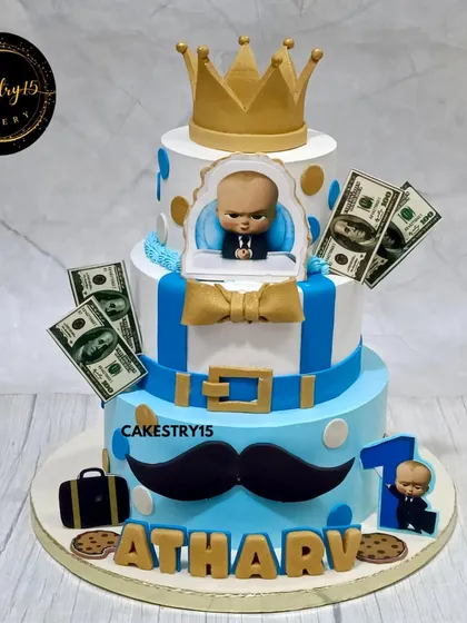 A stylish three-tier Boss Baby cake for a first birthday. This 4kg chocolate cake features the iconic suit, a golden crown, and edible money accents for a fun, "little boss" theme.
