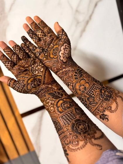 The reverse side of a bridal henna design, showing how the pattern continues from the front to the back of the hands.