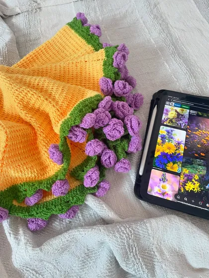 A close-up of the bouquet blanket's floral edge, with the inspiration board visible on the tablet in the background.