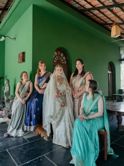 The bride with her bridesmaids, her dark henna stain standing out beautifully against her white wedding lehenga.