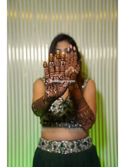 A playful shot of my bride showing off her intricate palm designs. The detailed work on the palms is the centerpiece of the bridal mehndi.
