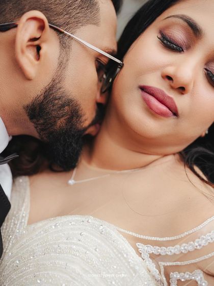 An intimate moment between Amaya and Deepak. The groom's gentle kiss speaks of tenderness and deep affection, a perfect candid moment for their wedding film.