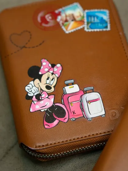 A close-up of the Minnie Mouse passport cover, complete with travel stamps and a little heart.