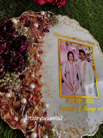 A close-up of the preserved flowers and personalized details in this wedding keepsake. The names, date, and infinity symbol make it a true celebration of the couple's love.