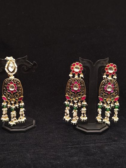 A pair of earrings showcasing red and green meenakari work, perfect for adding a pop of colour to your look.