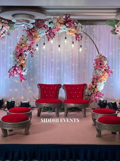 For this mandap, we used bold red chairs to contrast with a delicate floral ring backdrop, creating a striking balance between traditional color and modern design.