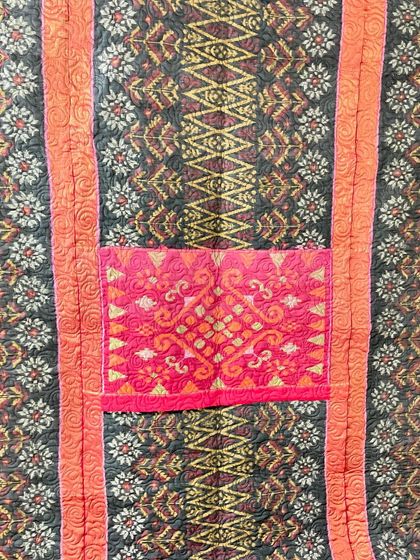 A close-up of the saree quilt, highlighting a vibrant pink 'pallu' section incorporated into the design.