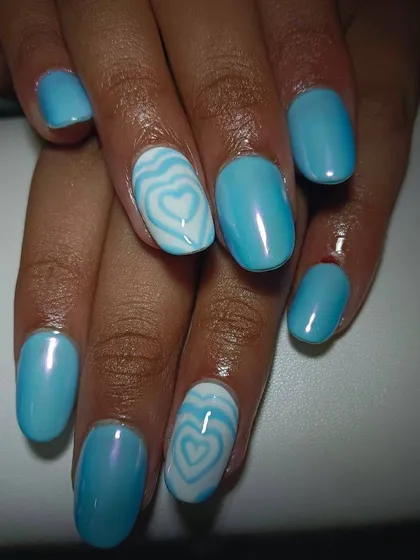 A pearly light blue base with a wavy, concentric heart design on the accent nail. This is a super cute and trendy look.
