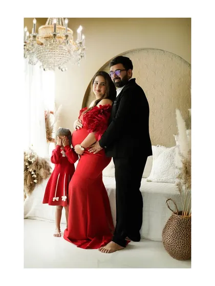 A beautiful family portrait from a maternity session, with the older sister shyly hiding. We embrace these real, imperfect moments that show the true personality of your family.