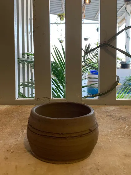 A wheel-thrown bowl with simple line details, sitting in our studio. A testament to the beauty of clean forms.