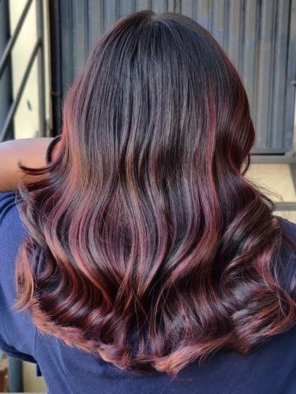 The final result of a student's red balayage project, showcasing glossy, healthy hair with beautiful movement. We emphasize techniques that maintain hair integrity while coloring.