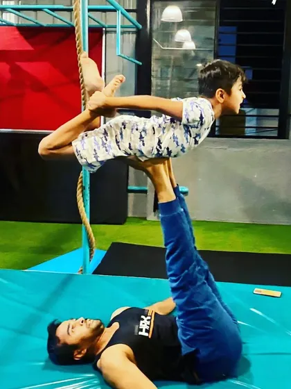 I often act as the base for my students in acro yoga. These images showcase various poses like 'bird' and 'throne', which are great for developing balance and core strength for the flyer.