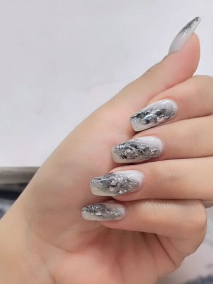 A modern and edgy design featuring a white base with a shattered silver foil effect, creating a textured, metallic look.