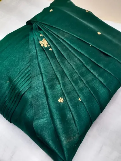 A beautiful emerald green saree with small gold buttis.