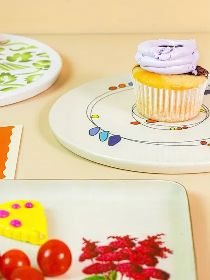 A cupcake presented on a unique, artistically designed plate, showcasing tableware for a home decor or crockery brand.
