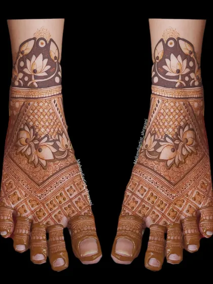 A symmetrical and intricate foot mehendi design. The pattern uses jaali (net) work and floral motifs to create a rich and detailed look.