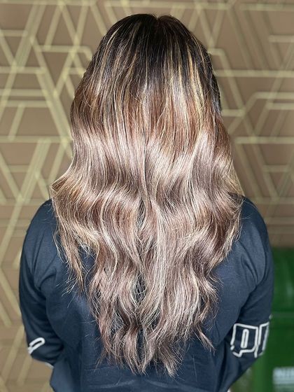 This custom balayage adds depth and dimension with sun-kissed shine. The soft waves perfectly showcase the hand-painted highlights.