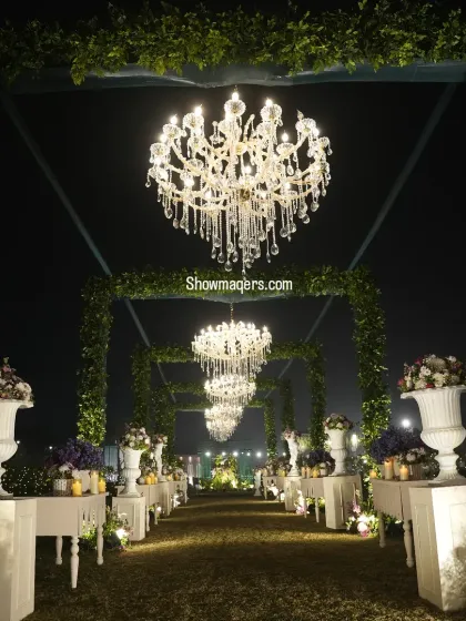 A grand entrance makes the first impression. For this Greek inspired wedding, we created a breathtaking walkway lined with lush floral arrangements and a series of magnificent crystal chandeliers, leading guests into an evening of elegance.