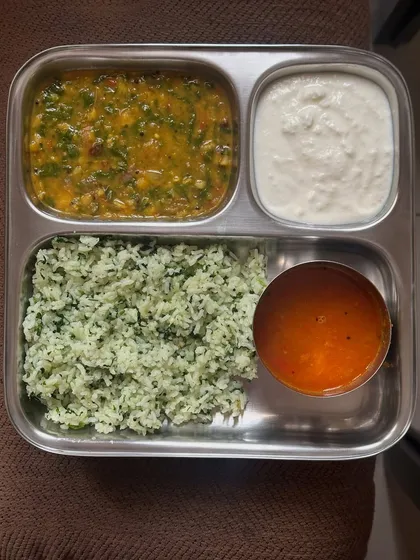 This plate has methi rice, dal, rasam, and raita. It's a light and comforting South Indian meal that is great for digestion.