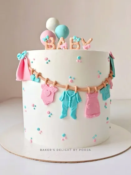 A lovely baby shower cake with a clothesline of tiny, handcrafted fondant baby clothes in pink and blue. This design is perfect for a gender-neutral celebration, topped with the word "BABY" and cute balloons.