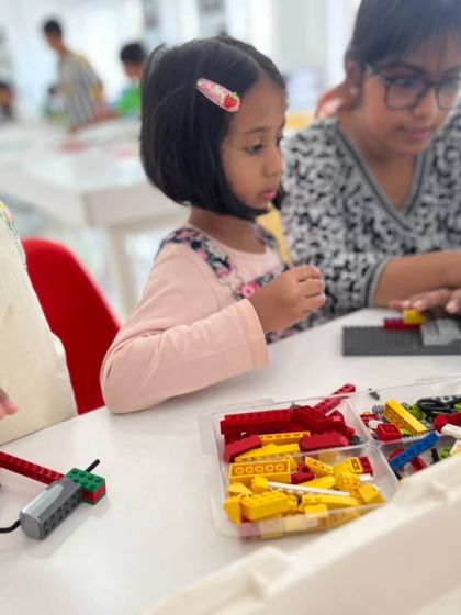 A young learner works with a LEGO WeDo kit, getting an early introduction to simple machines and programming concepts with guidance from an instructor.
