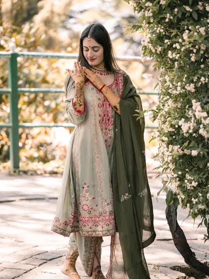 The bride admiring her intricate Mehandi design in the beautiful gardens of the wedding venue.