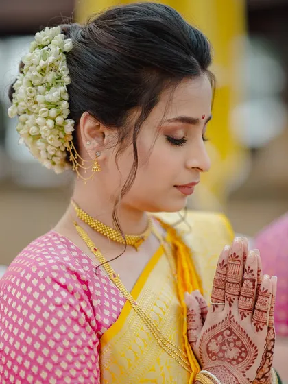 A moment of prayer. This close-up shows the intricate henna design and the beautiful, clean makeup look with a traditional bun.