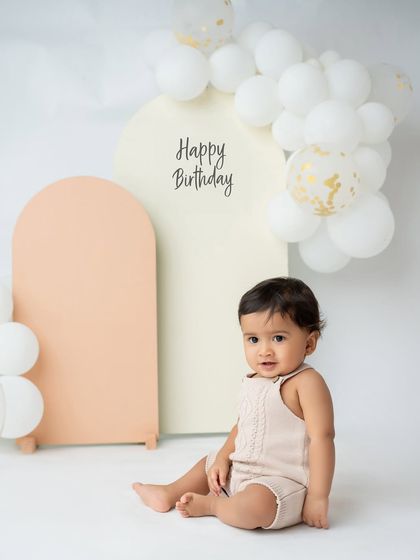 A simple and sweet first birthday portrait. The neutral tones of the background and outfit keep the focus on the baby.