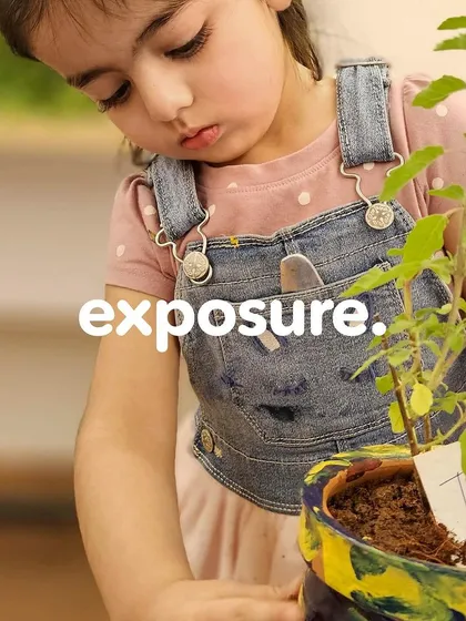 Exposure to new experiences is key to learning. A young girl in overalls holds her finished plant, a tangible result of her hard work.
