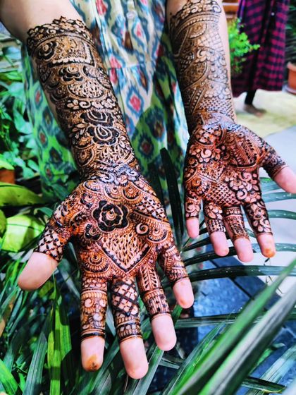 A lovely outdoor shot of bride Safeena's engagement henna, showing the detailed patterns on her palms and fingers.