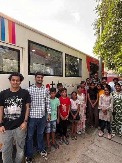 A side view of the Music Bus with our students and facilitators. The vibrant artwork on the bus reflects the creativity and energy we bring to every location we visit.