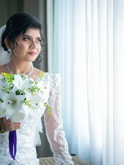 A beautiful bridal portrait by the window. The natural light highlights the bride's features and creates a soft, elegant mood.