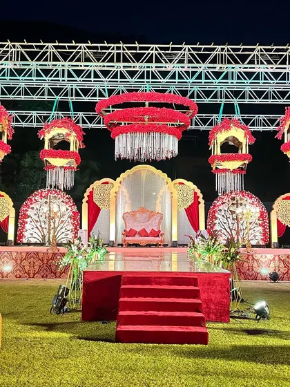 A full view of the reception stage, showcasing the hanging floral structures and the regal seating for the couple. This setup is designed to be a magnificent backdrop for photos.