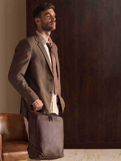 A shot highlighting a different style of bag, this time a modern leather briefcase. The overall look is professional and confident, tailored for a corporate audience.
