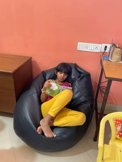 A duplicate shot of a girl enjoying her book in the bean bag chair, a popular spot in our library.